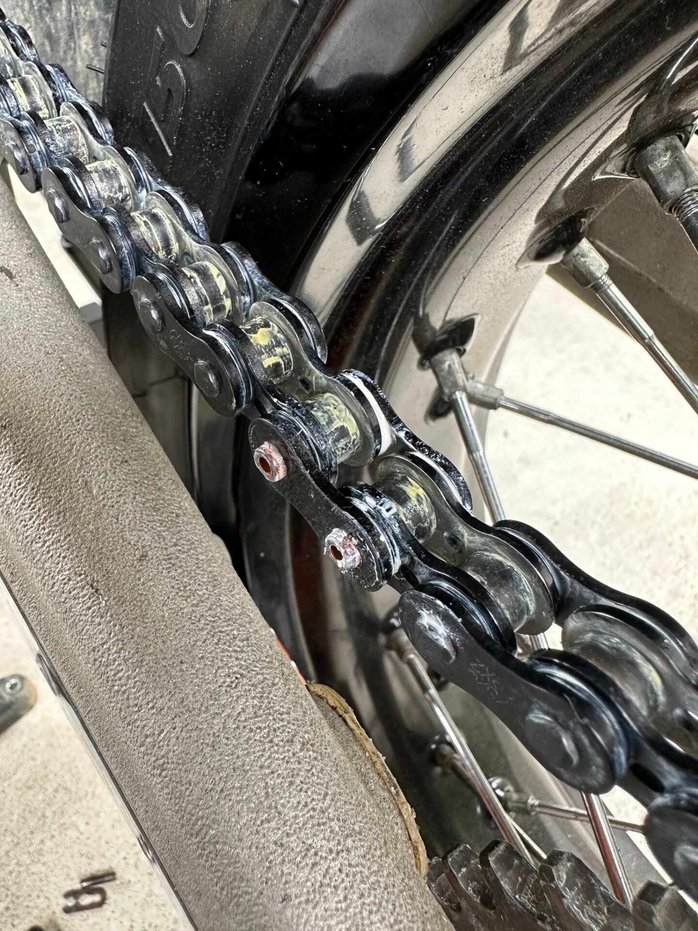 バイクの後輪付近にあるドライブチェーンのプレートとローラーの接写